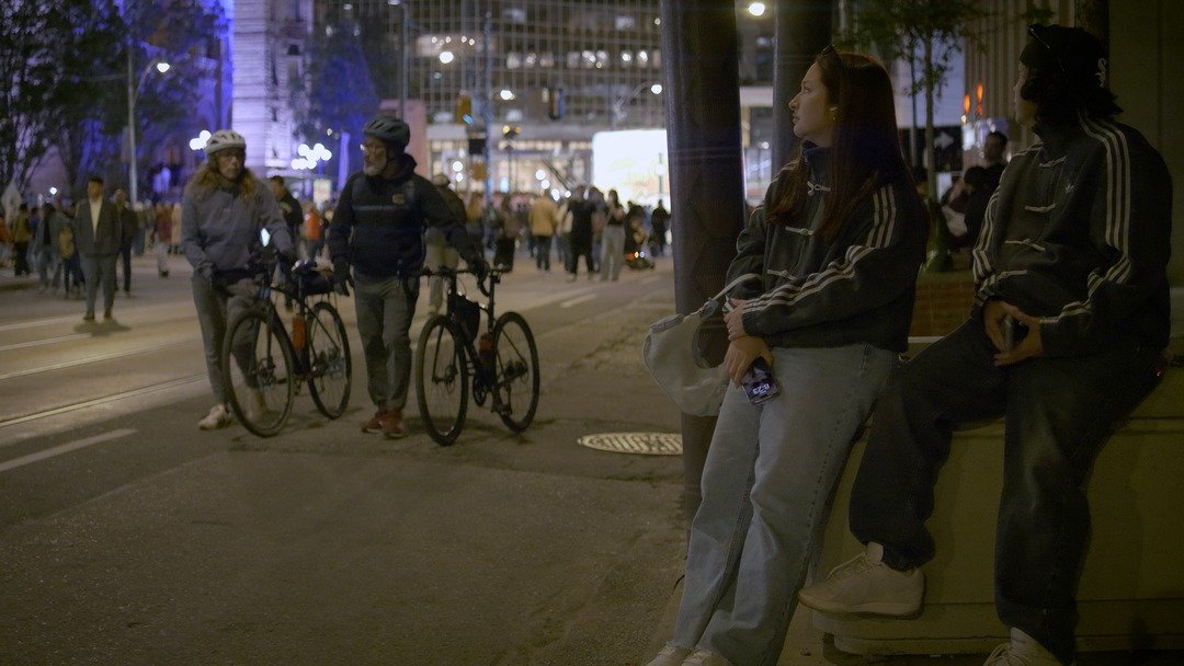 Night street at Nuit Blanche with cyclists and onlookers