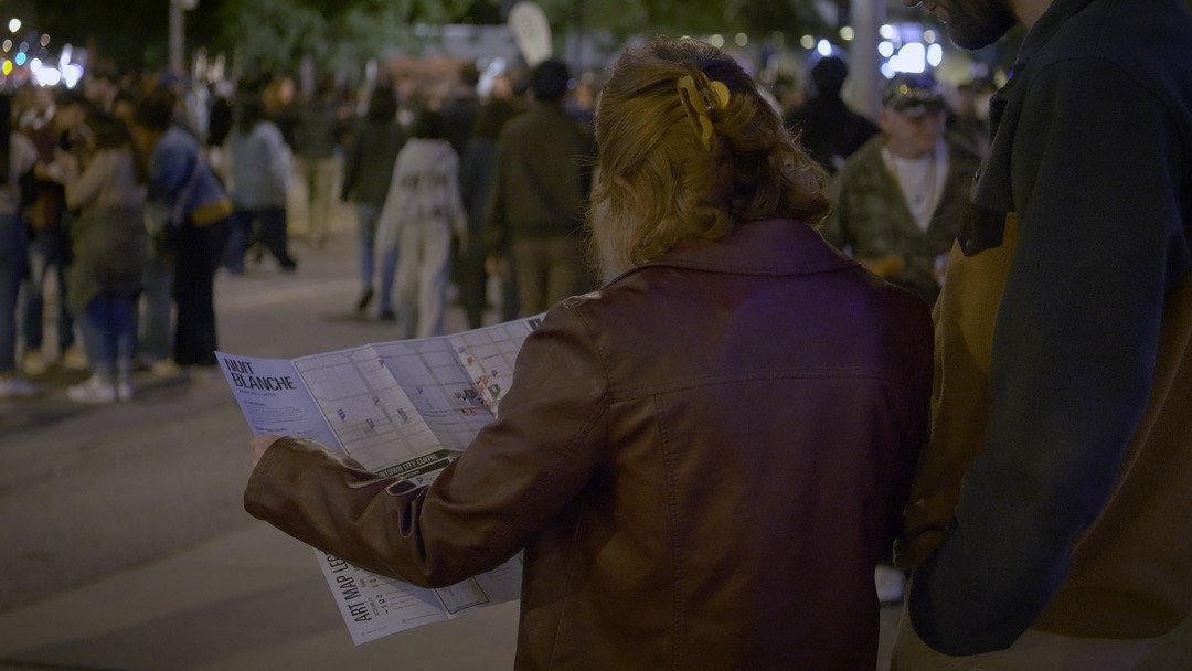 Visitor holding the Nuit Blanche art map