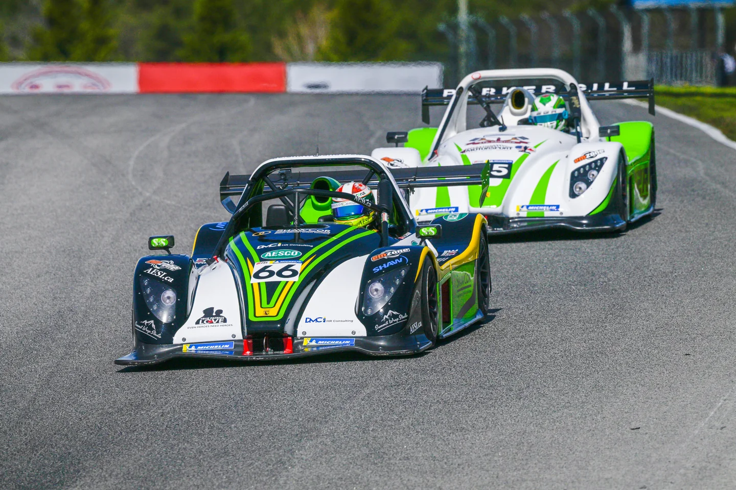 Two Radical prototype race cars cresting a corner at Mosport